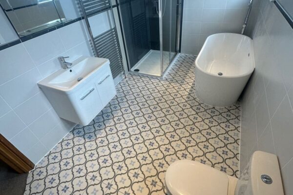 a grey bathroom with patterned floor tiles